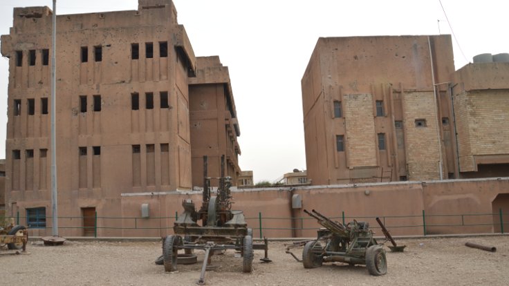 Binasının dış cephesinin rengi nedeniyle "Kızıl Emniyet" diye adlandırılan Amna Suraka'nın önünde Saddam'ın zırhlı araçları da var.
