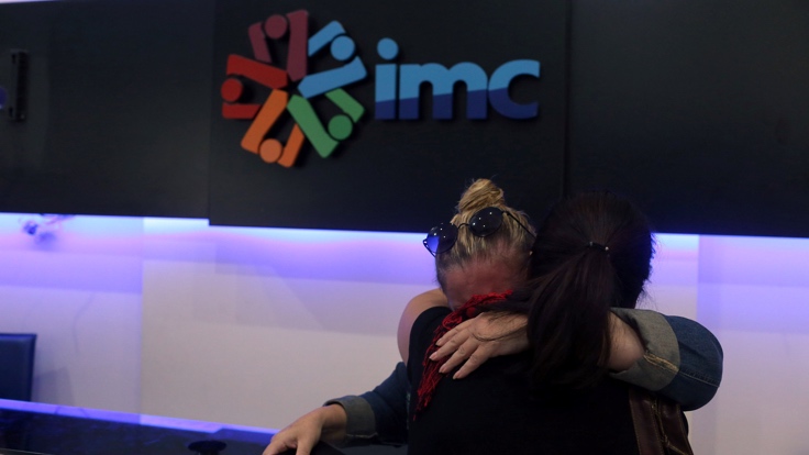 IMC TV employees react after their broadcaster's transmission cut by the authorities, based on a government decree, at IMC TV studios in Istanbul